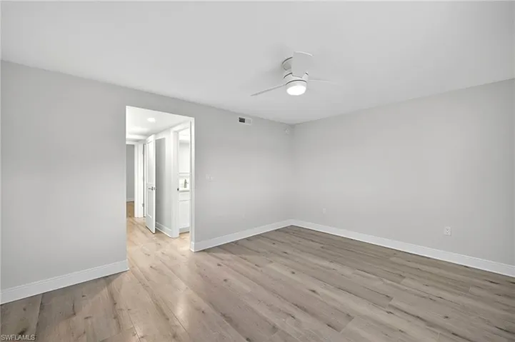 Empty room featuring light plank tile flooring and ceiling fan