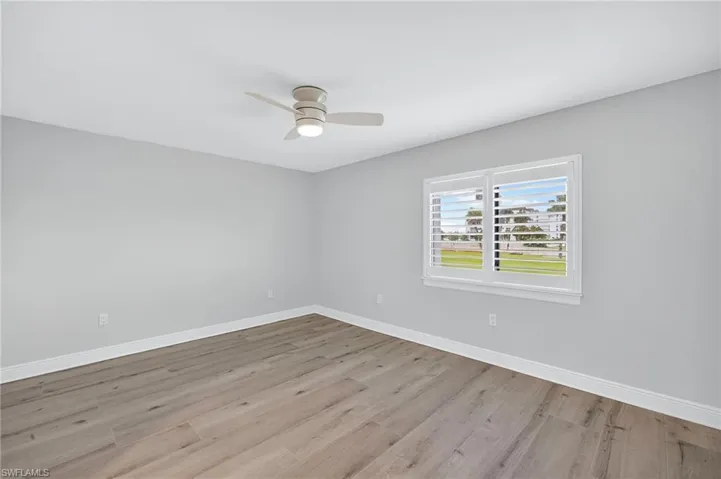 Empty room featuring light plank tiles flooring and ceiling fan