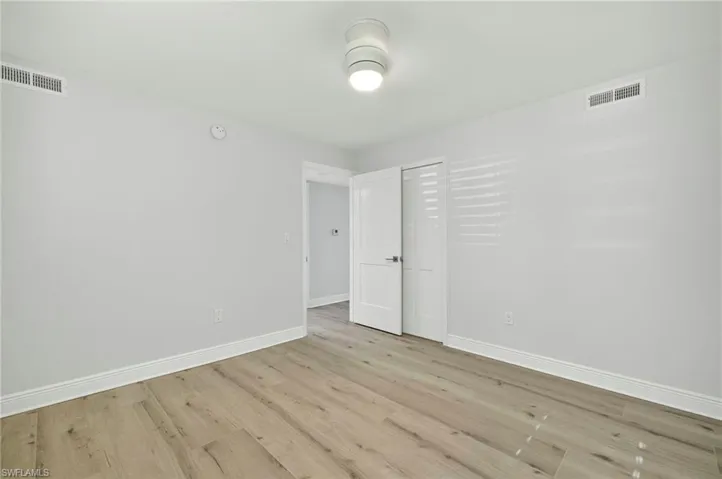 Unfurnished bedroom with light plank floors floors and baseboards