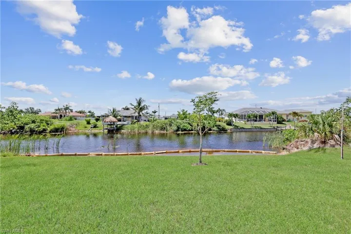 View of grassy yard with a water view and a residential view