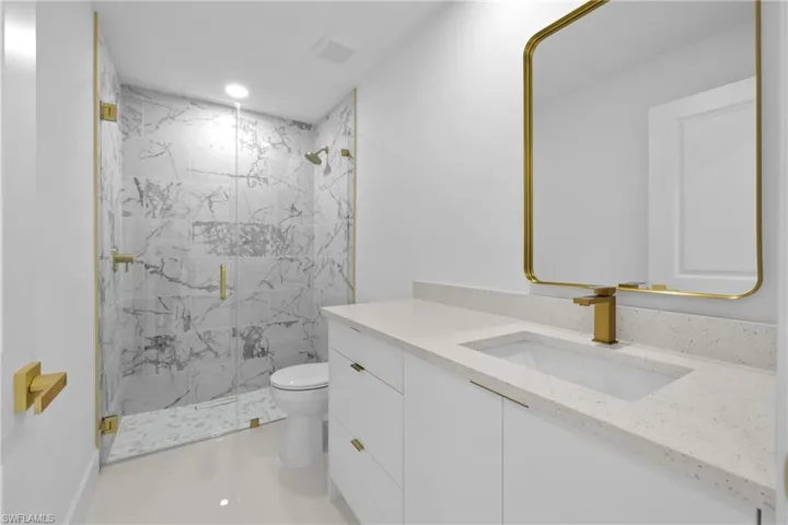 Full bathroom with a marble finish shower, vanity, and recessed lighting