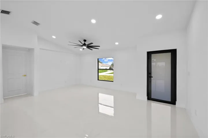 Empty room featuring recessed lighting, light tile patterned floors, a ceiling fan, and vaulted ceiling