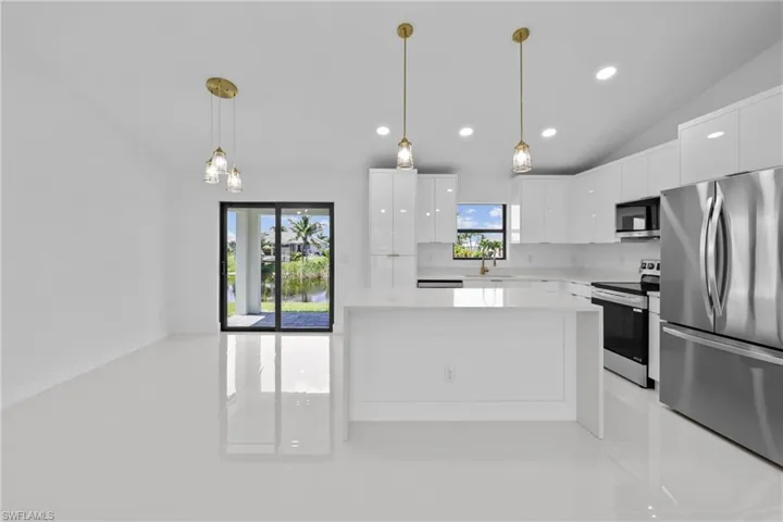 Kitchen with stainless steel appliances, modern cabinets, light countertops, white cabinetry, and recessed lighting
