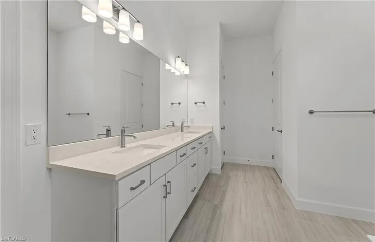 Bathroom featuring tile floors and dual bowl vanity