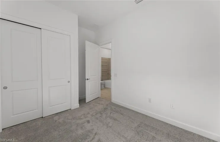 Unfurnished bedroom with carpet flooring and a closet