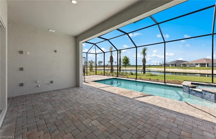 View of swimming pool with a lanai, an in ground hot tub, and a patio area with outdoor kitchen pre-plumb setup