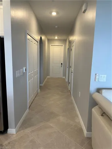 Corridor featuring light tile patterned floors. Newly paint walls.