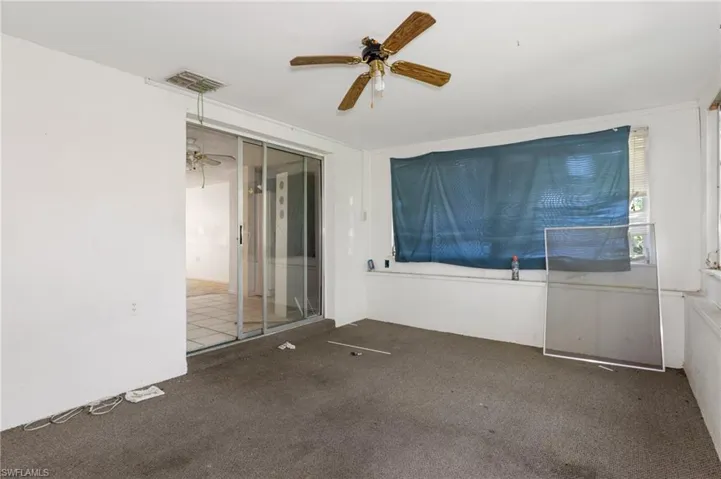 Empty room with ceiling fan and carpet floors