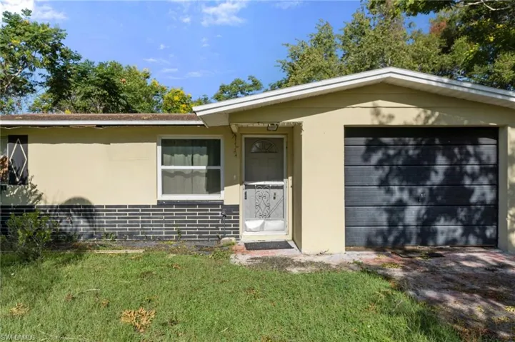 View of front of home with a front yard and a garage