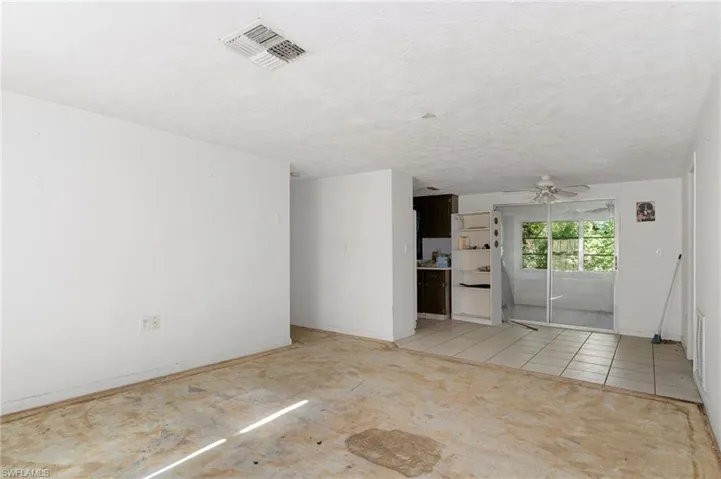 Unfurnished living room with light tile patterned floors, a textured ceiling, and ceiling fan