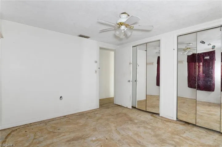 Unfurnished bedroom featuring ceiling fan and two closets