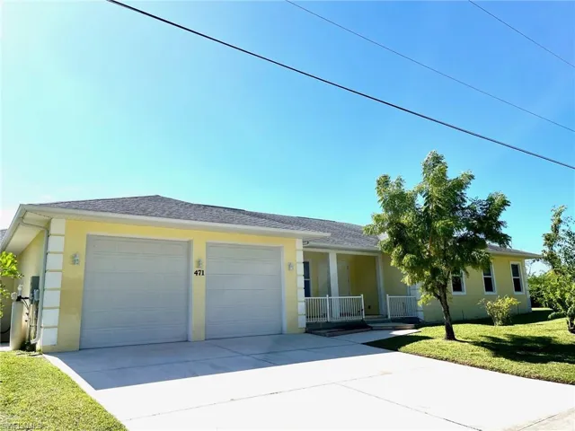 Single story home featuring covered porch, a garage, and a front lawn