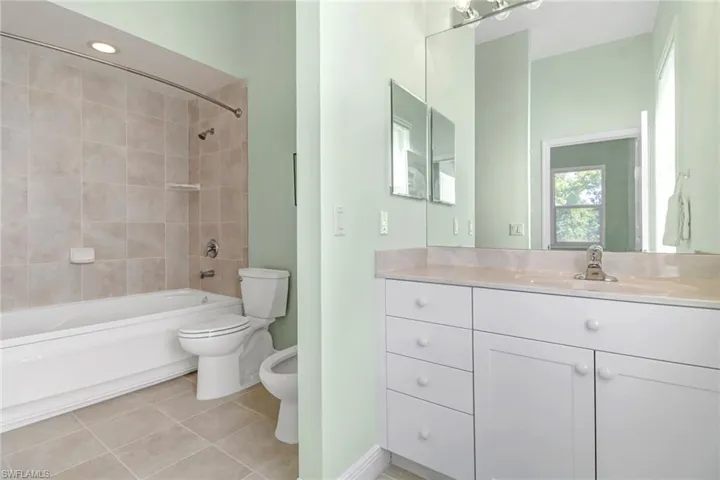 Master bathroom #2 with toilet, tile patterned floors, tiled shower / bath, vanity, and a bidet