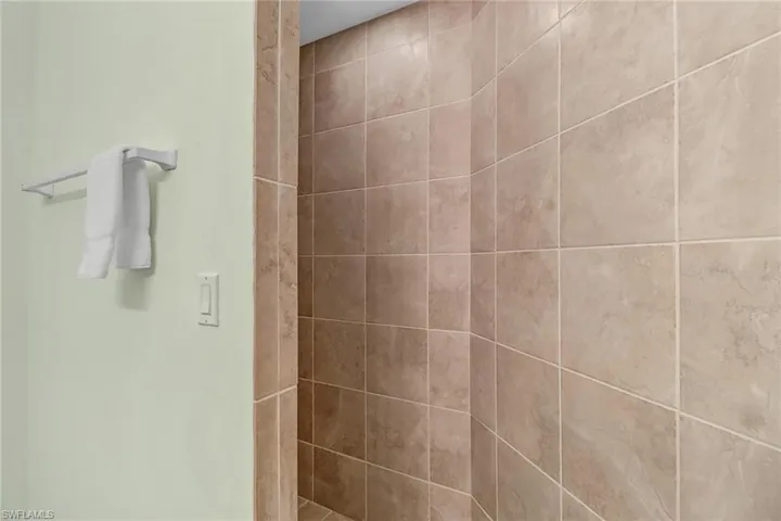 3rd Bathroom, interior room, adjacent to laundry room, featuring tiled, walk-in shower, vanity and toilet