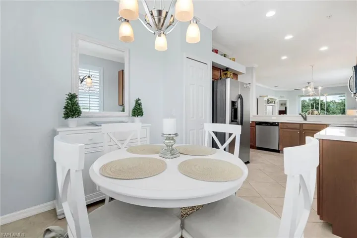 Tiled dining room with sink and an inviting chandelier