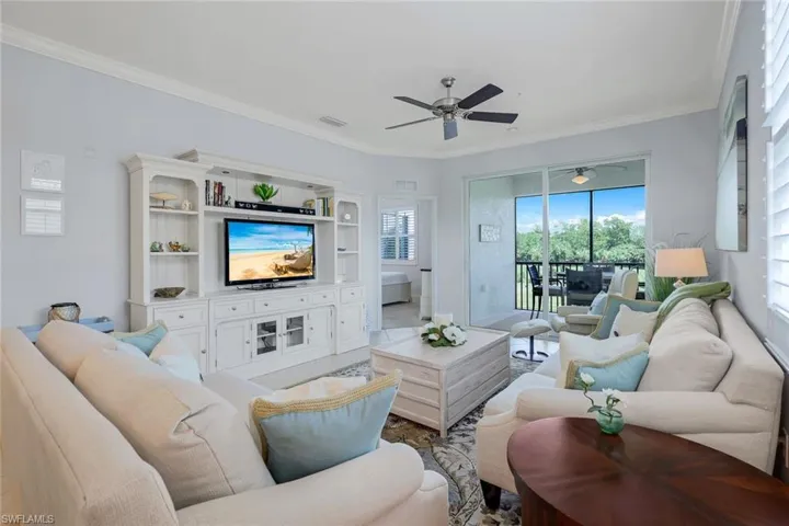 Living room featuring ceiling fan and crown molding