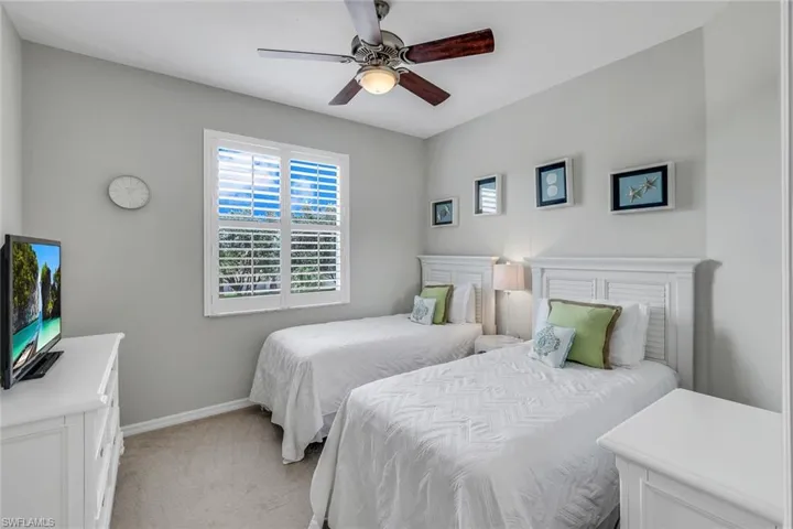 Bedroom with ceiling fan and light carpet