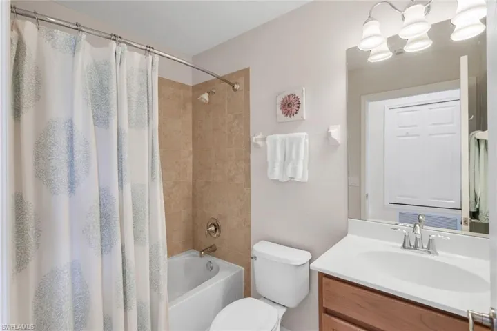 Full bathroom with shower / bath combination with curtain, toilet, and vanity