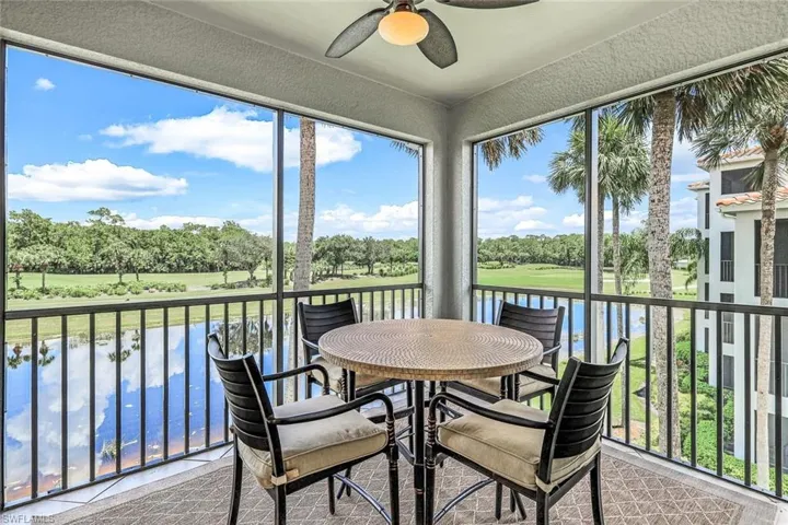 Sunroom with ceiling fan, a wealth of natural light, and a water view