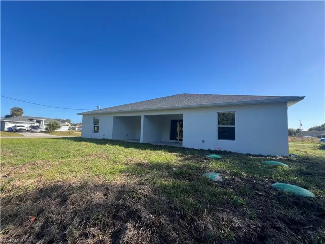 Back of property featuring a lawn