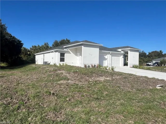 View of front of house with cooling unit and a garage