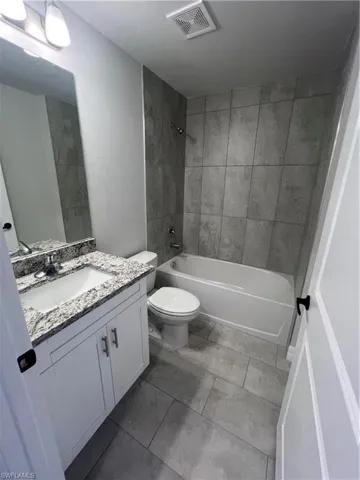 Full bathroom featuring vanity, toilet, and tiled shower / bath
