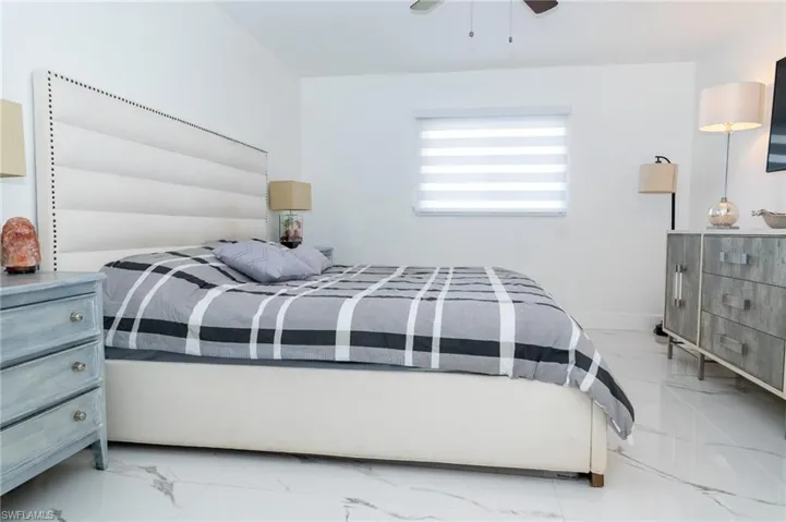 Bedroom with porcelain finish floors and ceiling fan