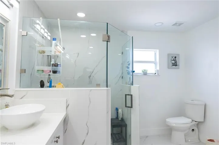 Full bathroom with marble finish floors, a marble finish shower, vanity, and recessed lighting