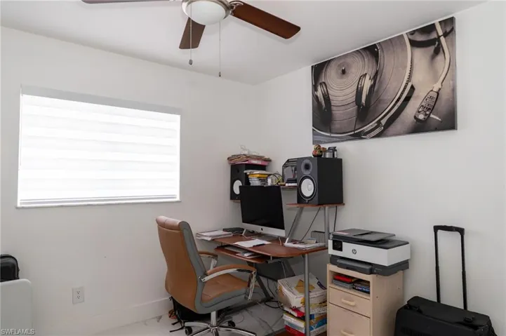 Office area with ceiling fan and baseboards