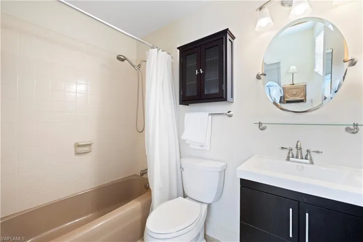 Bathroom featuring shower / bathtub combination with curtain and vanity