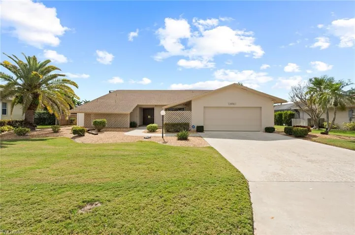 Ranch-style home with a garage and a front lawn