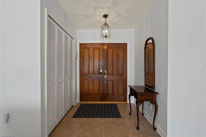 Tiled foyer featuring a notable chandelier
