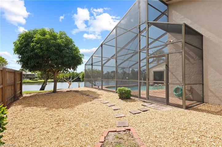 View of yard with a patio, a water view, and glass enclosure