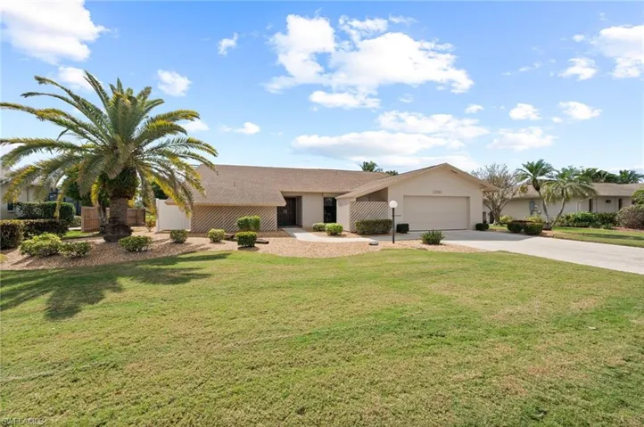 Single story home featuring a garage and a front lawn