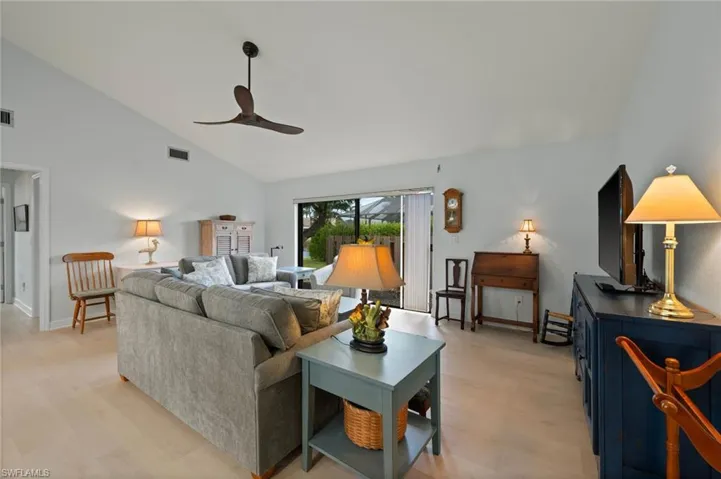 Living room featuring light hardwood / wood-style flooring, high vaulted ceiling, and ceiling fan