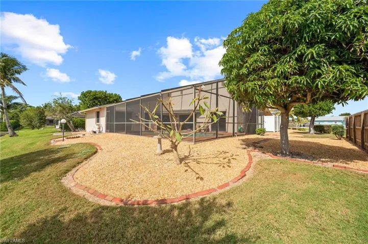 Rear view of property with a yard and a lanai