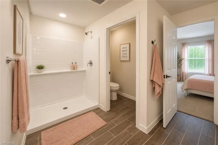Bathroom featuring a shower with white subway tile surround, integrated shelf, and chrome fixtures