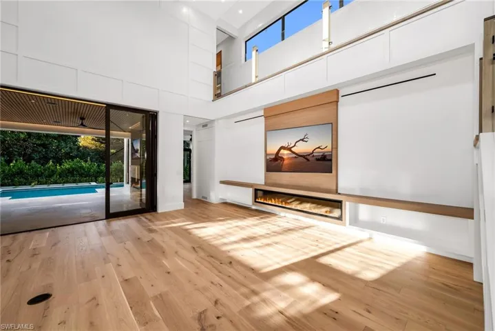 View 2 - Open living area overlooking the pool, highlighted by soaring 22’ ceilings and an airy, expansive feel.