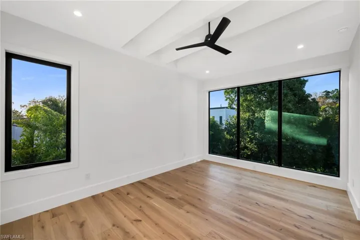 Upstairs primary suite overlooking the pool, complete with a private balcony retreat.