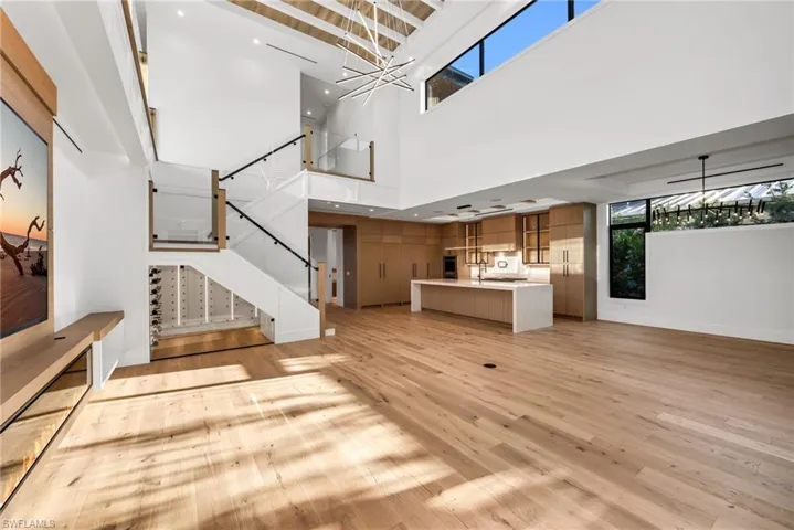 Seamless flow from living to kitchen, highlighted by custom under-stair wine storage with elegant low-voltage lighting.