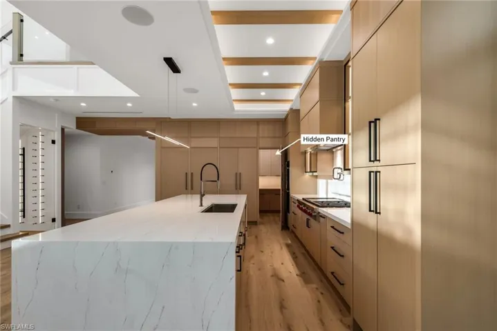 Custom white oak cabinetry with a seamlessly hidden pantry for a clean, elevated look.
