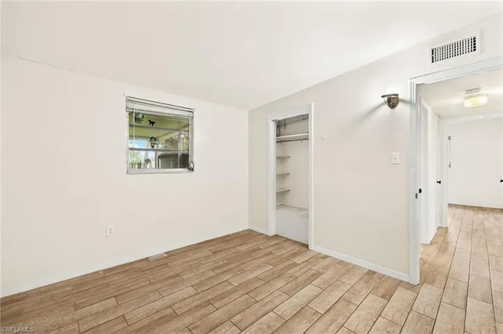 Unfurnished bedroom with light wood-style flooring, baseboards, and a closet
