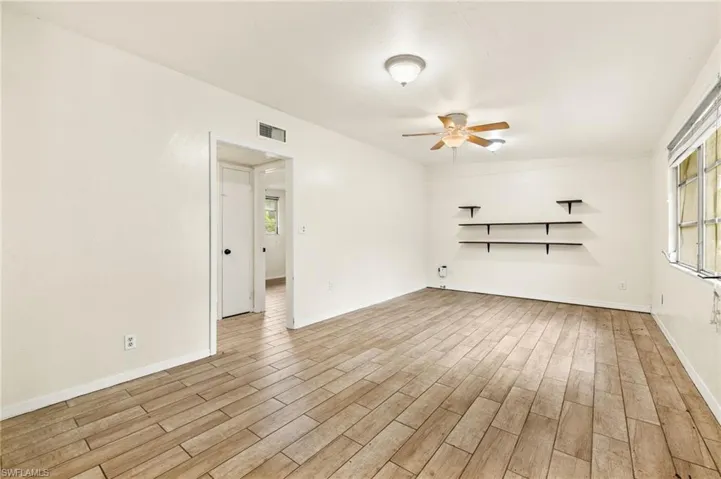 Unfurnished room featuring ceiling fan, light wood finished floors, and baseboards