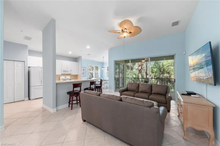 Tiled living room featuring plenty of natural light and ceiling fan