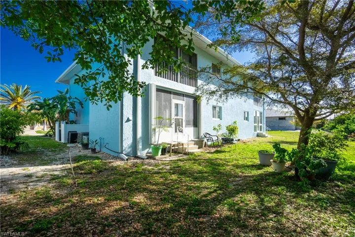 View of property exterior featuring a balcony and a lawn