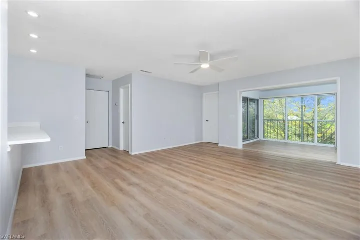 Unfurnished living room featuring ceiling fan and light hardwood / wood-style flooring