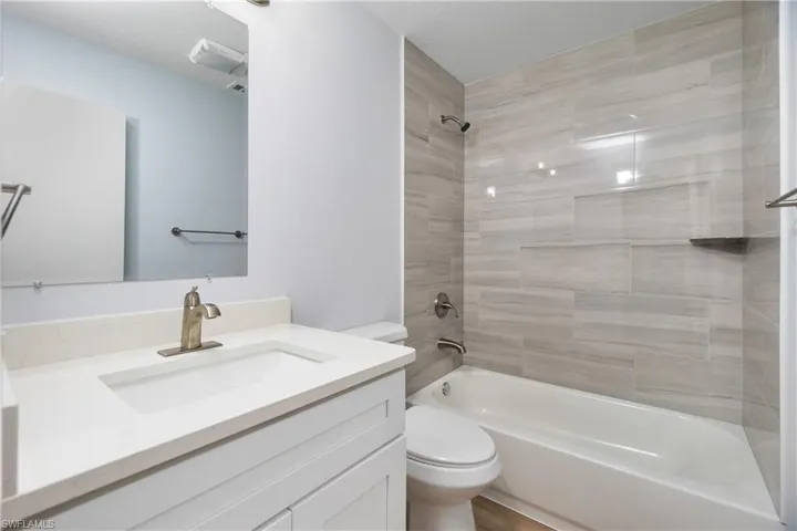 Full bathroom featuring vanity, toilet, and tiled shower / bath combo