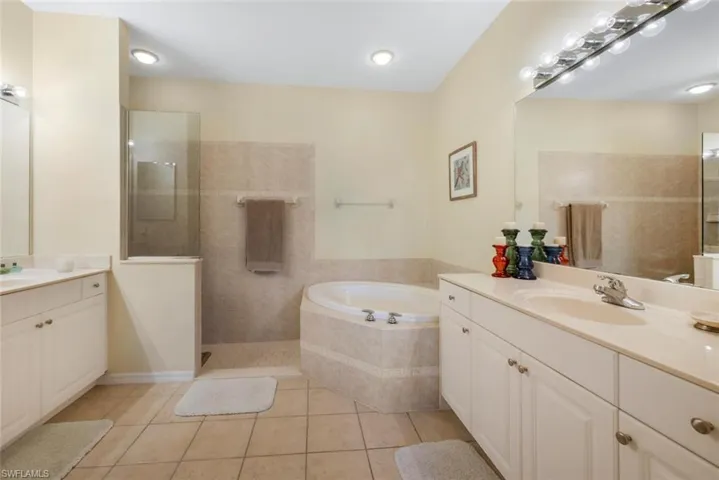 Bathroom with tile floors, separate shower and tub, and vanity