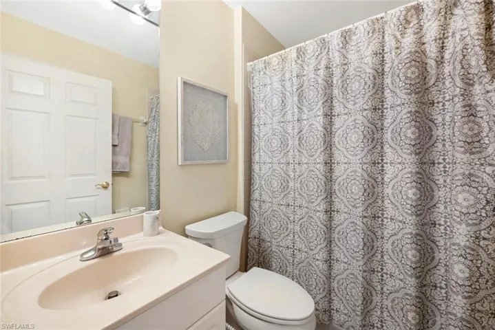 Bathroom featuring vanity with extensive cabinet space and toilet