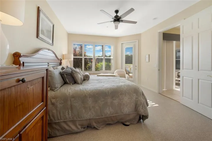 Carpeted bedroom with ceiling fan and access to outside
